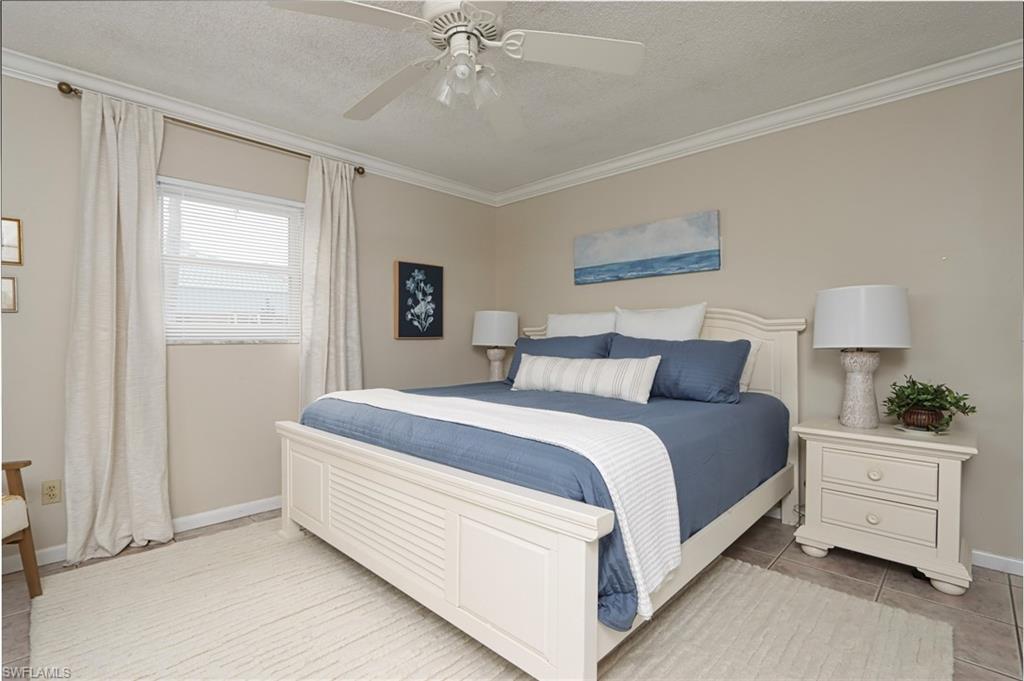940 3rd Street South, Unit 101 Naples, FL 34102 - Photo 4 of 20 Bedroom with a textured ceiling, ornamental molding, a ceiling fan, and light tile patterned flooring