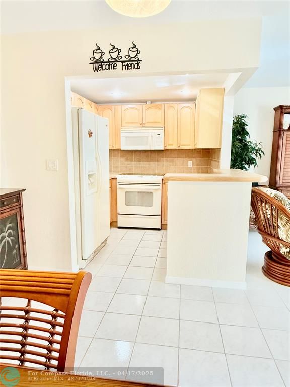 42 Tilford C, Unit 42 Deerfield Beach, FL 33442 - Photo 12 of 50 a kitchen with a stove a sink and a refrigerator