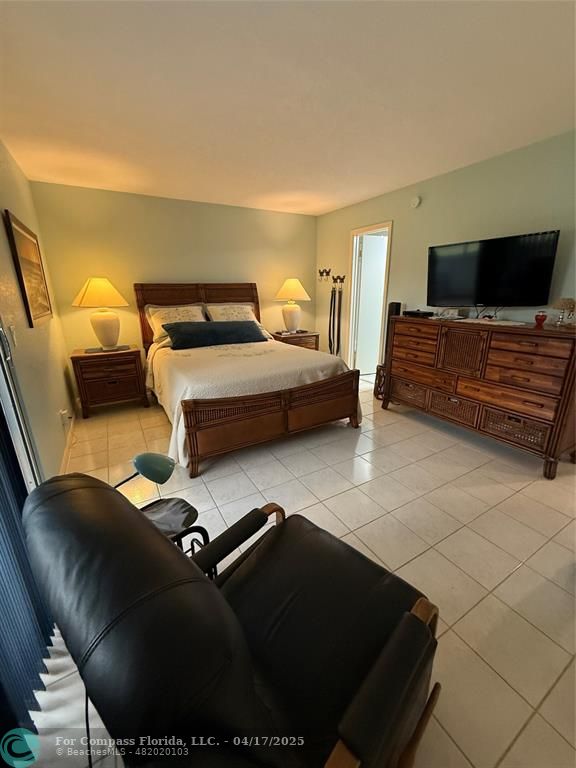 42 Tilford C, Unit 42 Deerfield Beach, FL 33442 - Photo 16 of 50 a bedroom with a bed and glass door