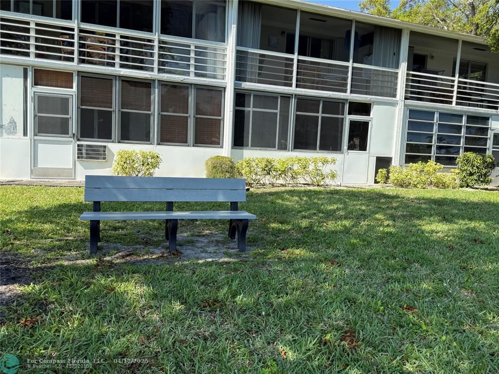 42 Tilford C, Unit 42 Deerfield Beach, FL 33442 - Photo 28 of 50 a wooden bench sitting in front of a house