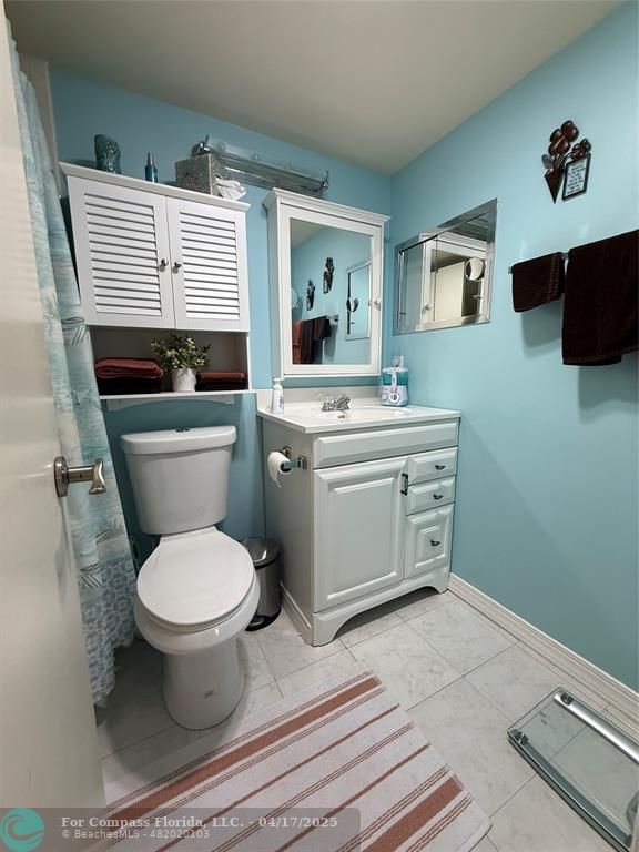 42 Tilford C, Unit 42 Deerfield Beach, FL 33442 - Photo 37 of 50 a bathroom with a toilet sink and mirror