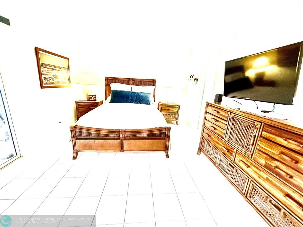 42 Tilford C, Unit 42 Deerfield Beach, FL 33442 - Photo 49 of 50 a spacious bedroom with a bed and a flat screen tv