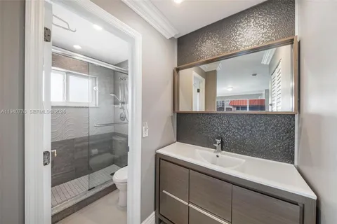 a bathroom with a shower sink and mirror