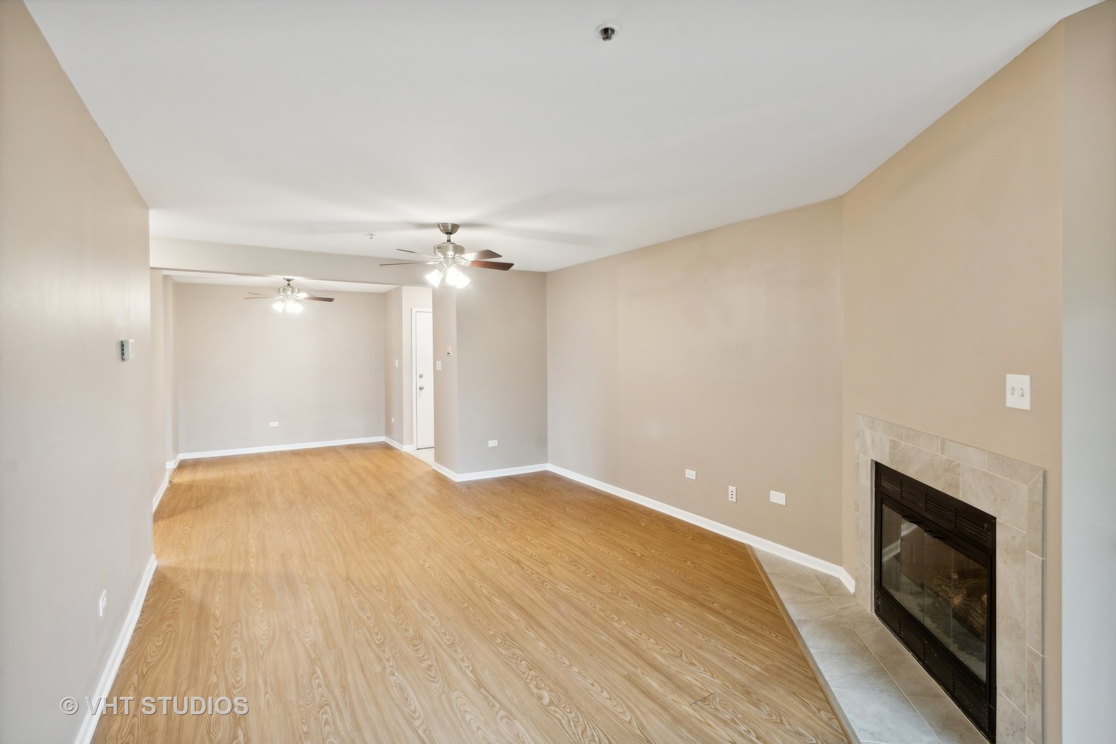 740 Weidner Road, Unit 106 Buffalo Grove, IL 60089 - Photo 5 of 17 a view of empty room with wooden floor and fireplace
