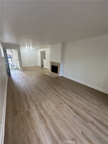 a view of empty room with wooden floor and fireplace