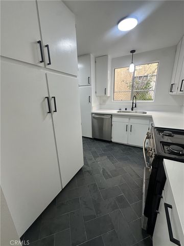 a kitchen with a sink a stove a refrigerator and cabinets