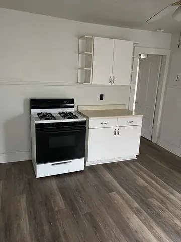 a kitchen with a stove and white cabinets