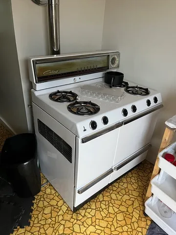 a white stove top oven sitting inside of a kitchen