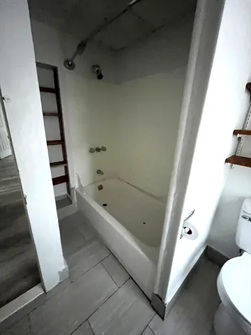 a bathroom with a tub and toilet