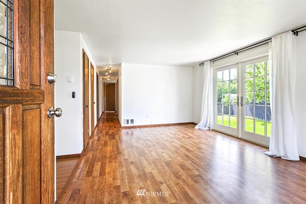 1310 233rd Place Southwest Bothell, WA 98021 - Photo 3 of 21 a view of an empty room with wooden floor and a window