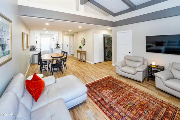 a kitchen with stainless steel appliances a sink a stove a refrigerator cabinets and a dining table