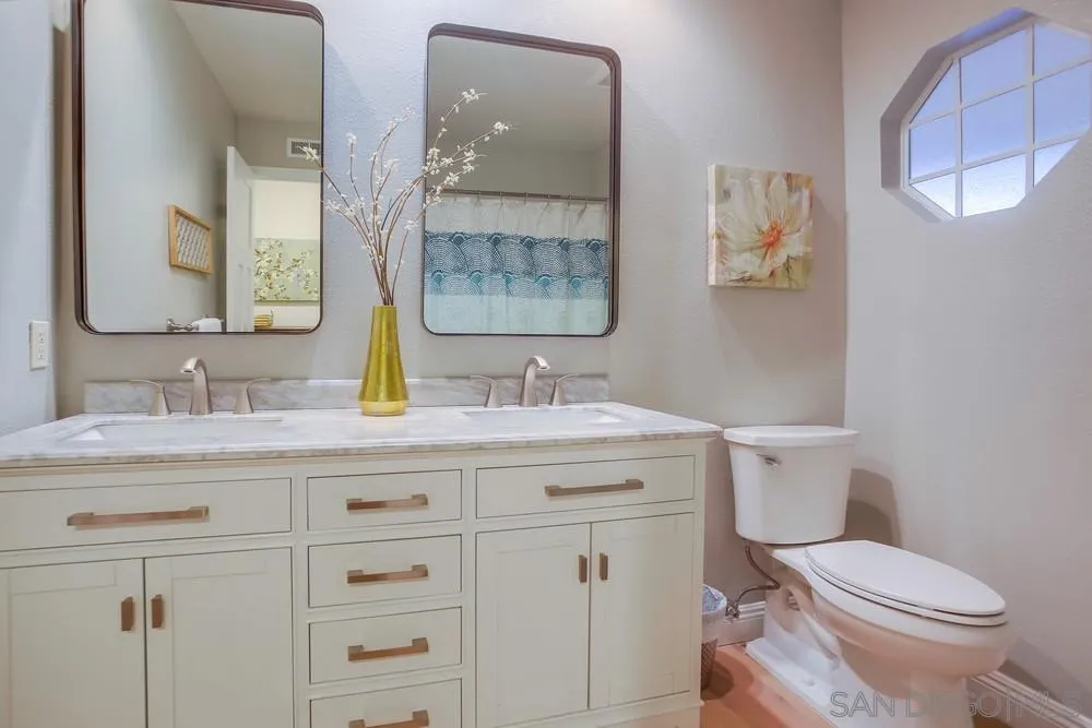 3534 Avenida Sierra Escondido, CA 92029 - Photo 24 of 38 a bathroom with a granite countertop toilet sink and mirror