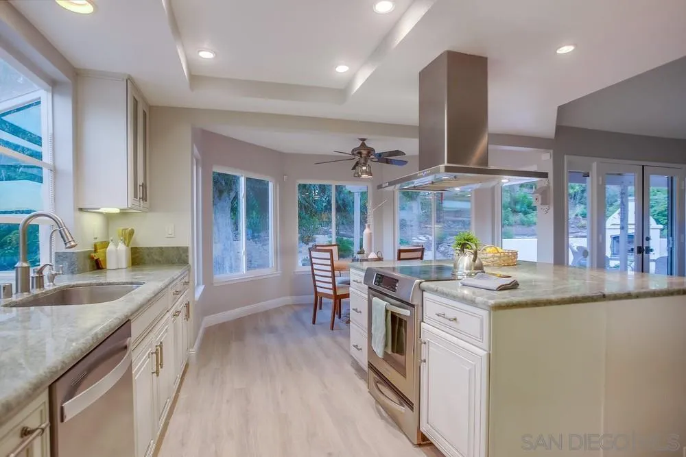 3534 Avenida Sierra Escondido, CA 92029 - Photo 9 of 38 a kitchen with stainless steel appliances granite countertop a sink a stove and a wooden floors