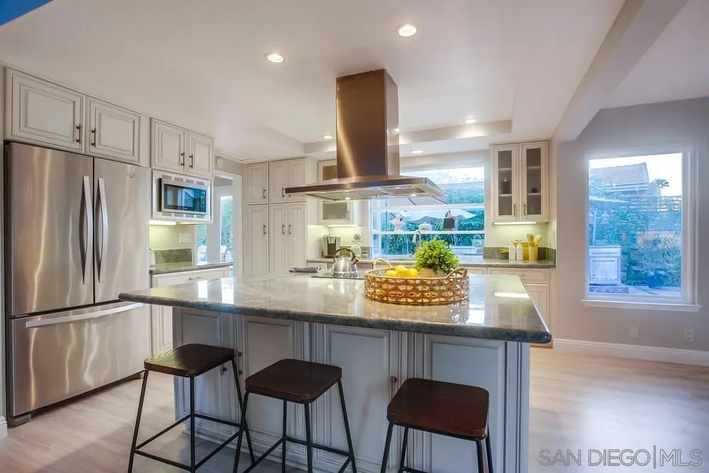 3534 Avenida Sierra Escondido, CA 92029 - Photo 10 of 38 a kitchen with stainless steel appliances granite countertop a table chairs refrigerator and sink