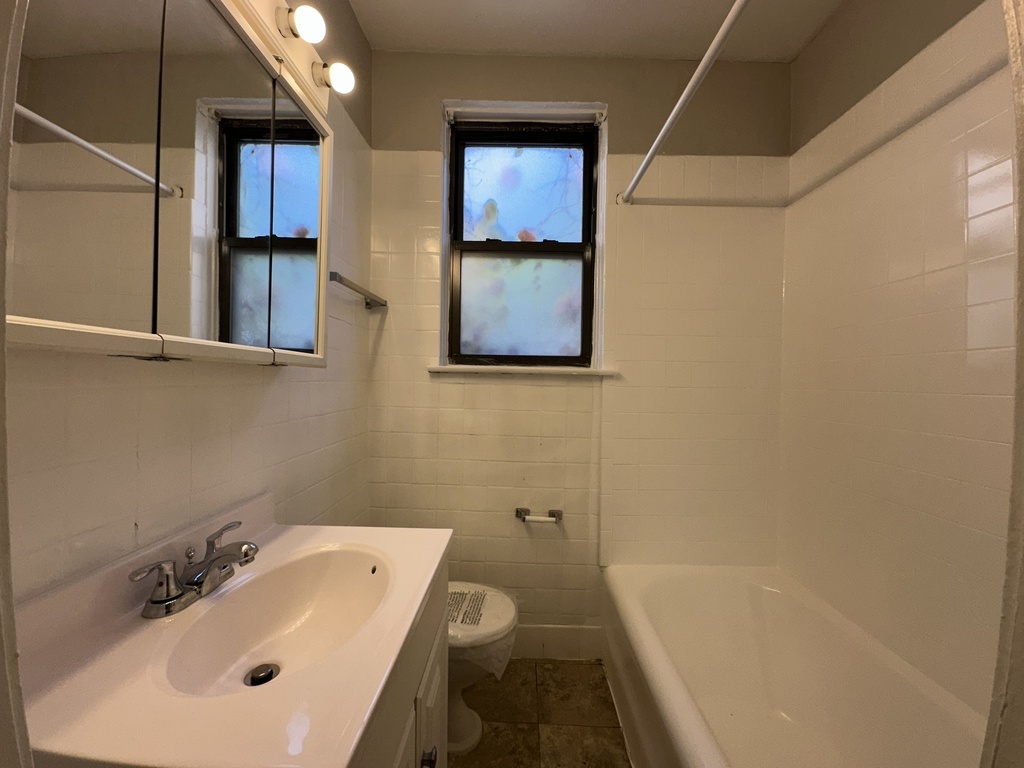 661 West Sheridan Road, Unit 208 Chicago, IL 60613 - Photo 17 of 20 a bathroom with a sink mirror and toilet