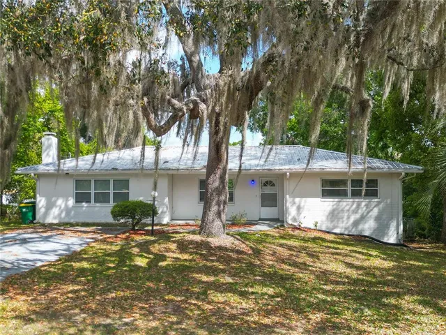 a view of a house with backyard and tree