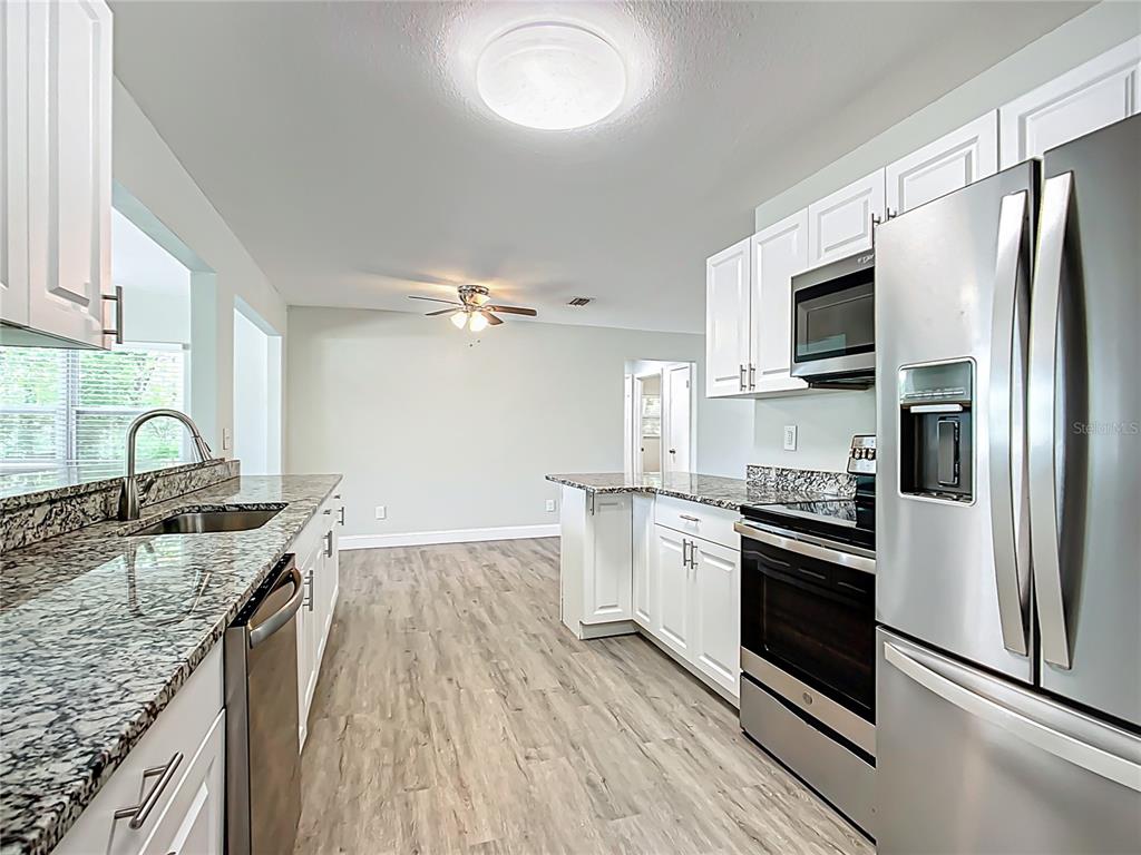 1406 Eden Drive Inverness, FL 34450 - Photo 11 of 41 a kitchen with stainless steel appliances granite countertop a sink stove microwave and refrigerator