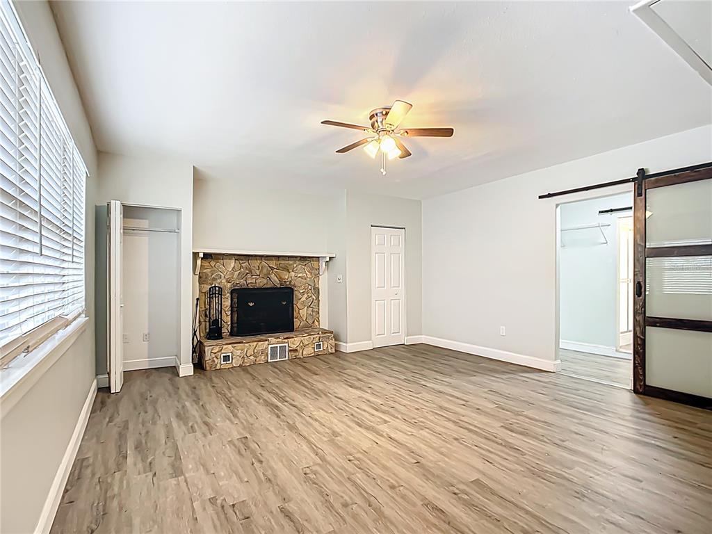 1406 Eden Drive Inverness, FL 34450 - Photo 16 of 41 an empty room with wooden floor and a fireplace