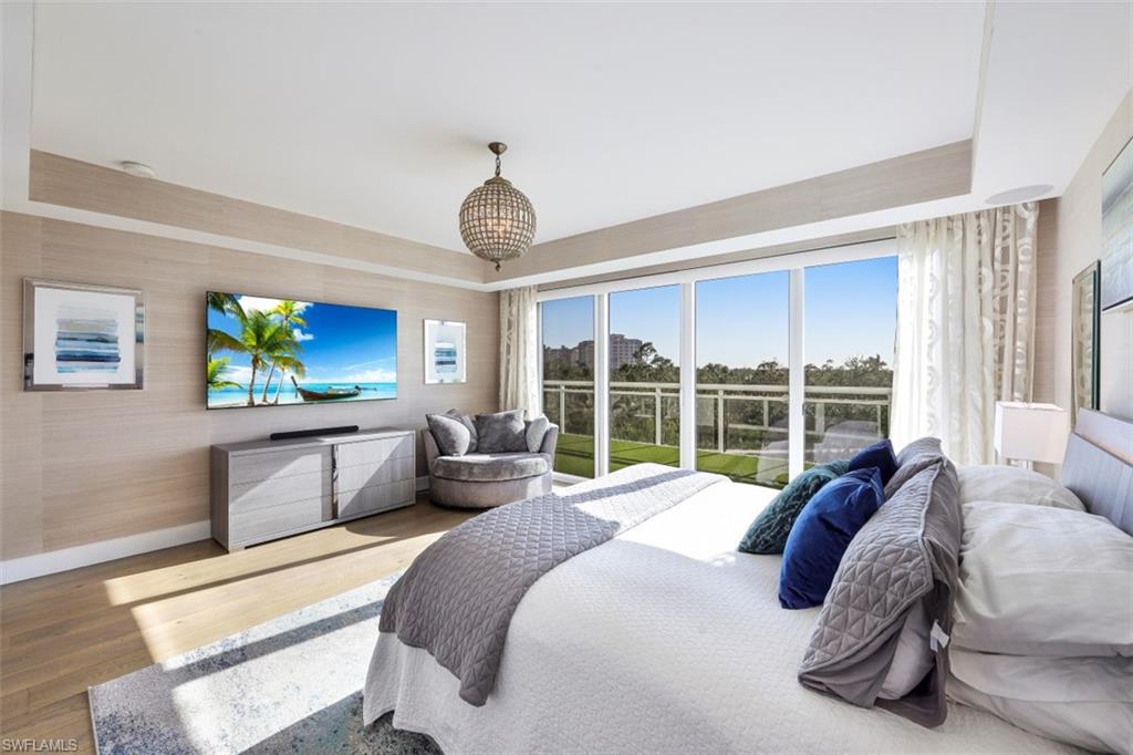 13915 Old Coast Road, Unit 305 Naples, FL 34110 - Photo 12 of 41 a large bedroom with a bed and glass window