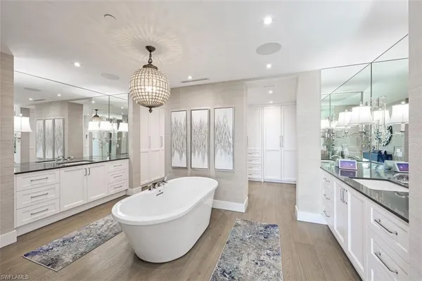 a bathroom with a tub sink and mirror