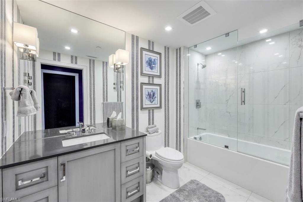 13915 Old Coast Road, Unit 305 Naples, FL 34110 - Photo 18 of 41 a bathroom with a granite countertop sink a toilet a mirror and shower