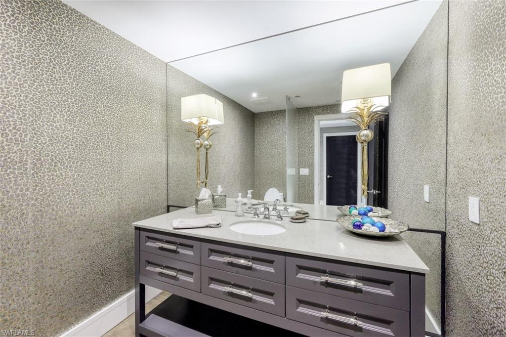 13915 Old Coast Road, Unit 305 Naples, FL 34110 - Photo 20 of 41 a bathroom with a sink mirror and vanity