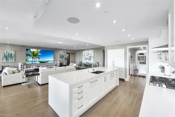 a large white kitchen with a large window and stainless steel appliances