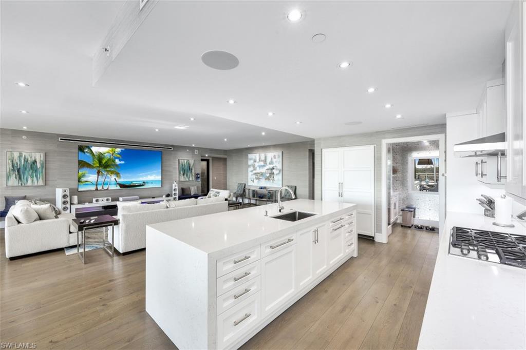 13915 Old Coast Road, Unit 305 Naples, FL 34110 - Photo 4 of 41 a large white kitchen with a large window and stainless steel appliances