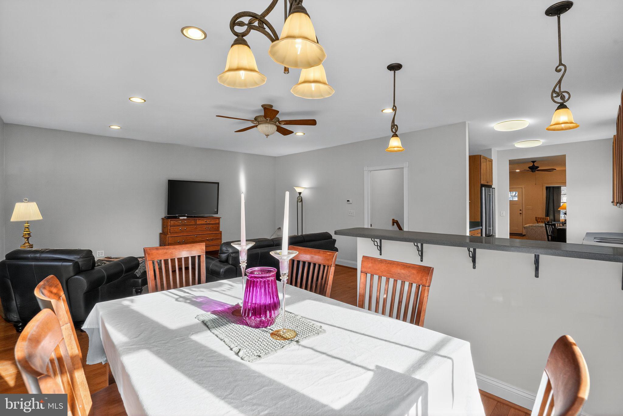 9260 Old Scaggsville Road Laurel, MD 20723 - Photo 16 of 48 a view of a dining room and livingroom with furniture wooden floor a chandelier
