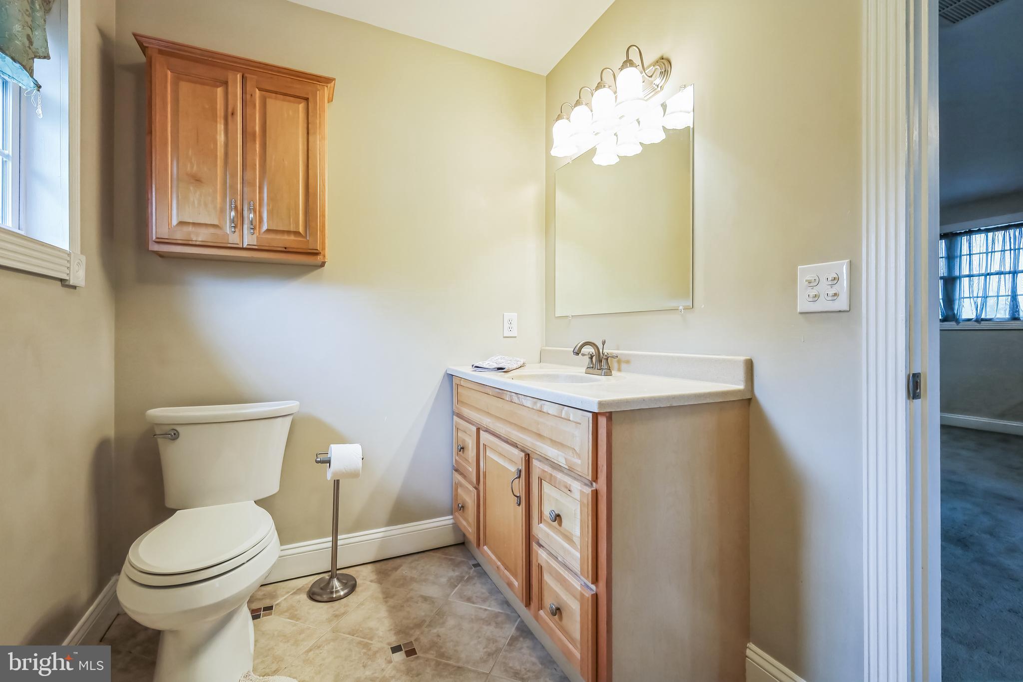 9260 Old Scaggsville Road Laurel, MD 20723 - Photo 23 of 48 a spacious bathroom with a toilet sink and mirror