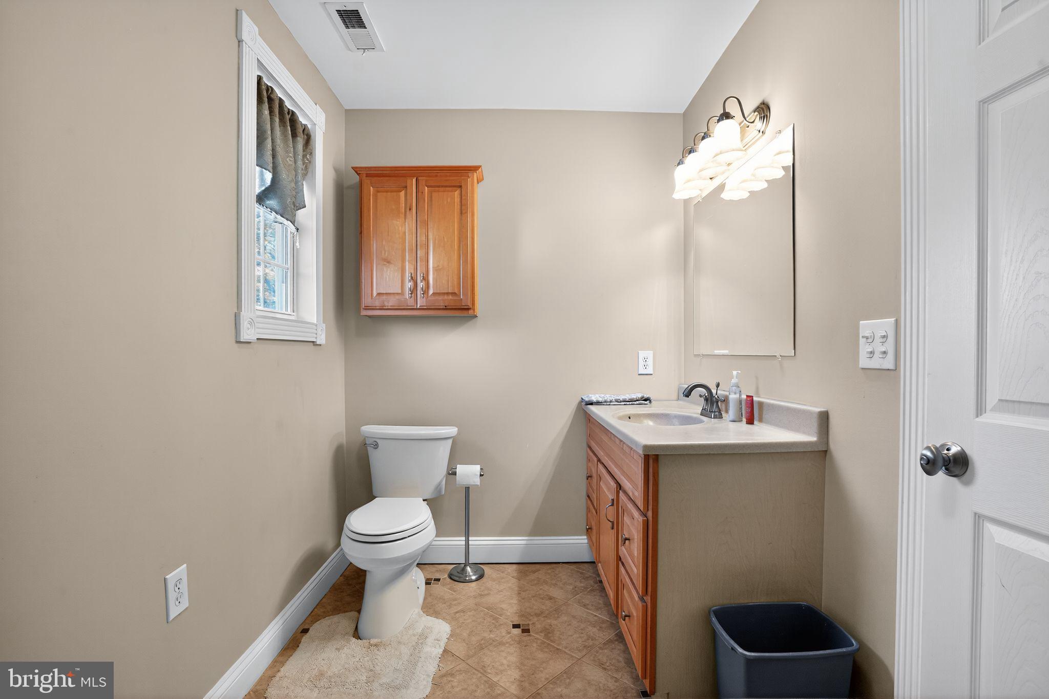 9260 Old Scaggsville Road Laurel, MD 20723 - Photo 24 of 48 a bathroom with a toilet a sink and mirror