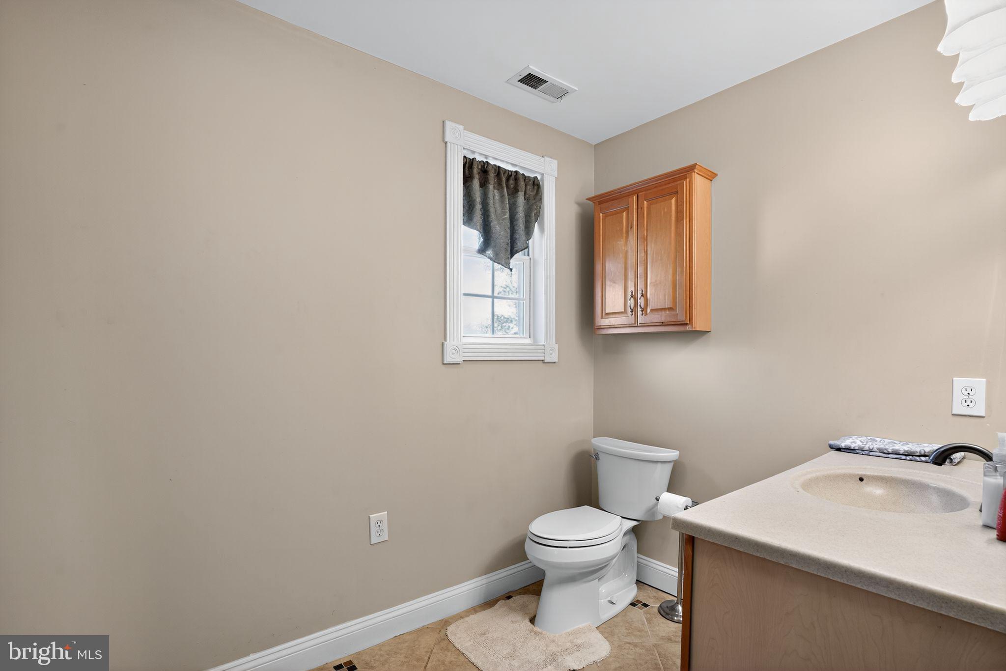 9260 Old Scaggsville Road Laurel, MD 20723 - Photo 26 of 48 a bathroom with a toilet a sink and mirror
