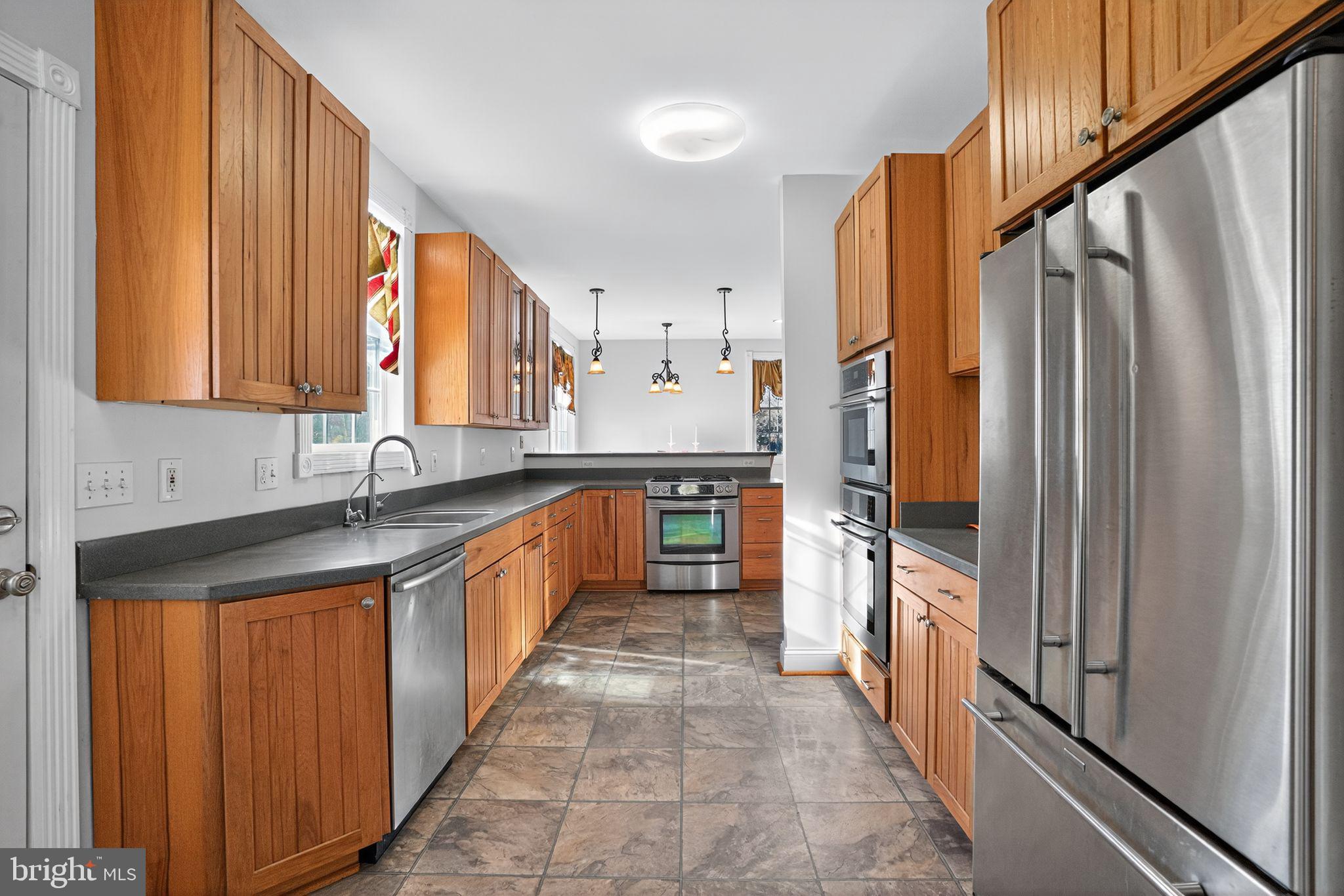 9260 Old Scaggsville Road Laurel, MD 20723 - Photo 4 of 48 a large kitchen with stainless steel appliances granite countertop a refrigerator a stove and a sink