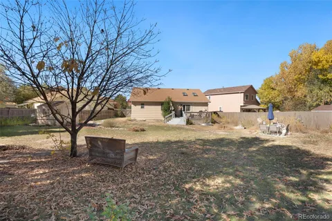 a view of a yard with wooden fence