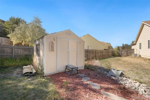 a view of backyard of house with wooden fence