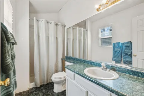 a bathroom with a granite countertop sink toilet and a mirror
