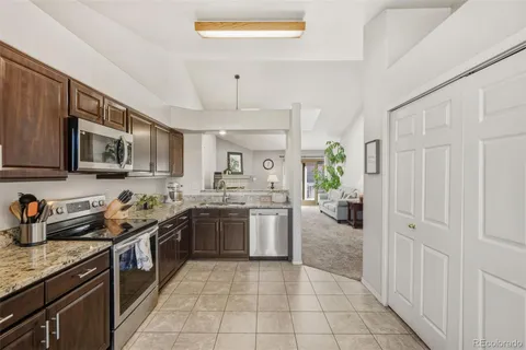 a kitchen with stainless steel appliances granite countertop a sink and stove top oven