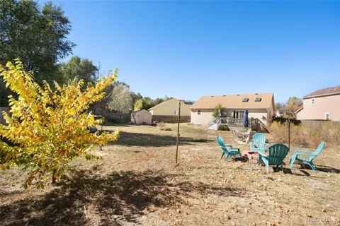 a view of a backyard with a table and chairs under an umbrella