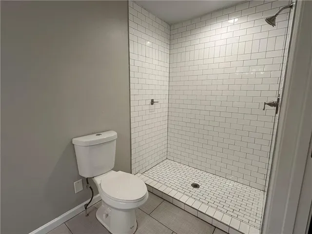 a bathroom with a shower a toilet and a sink