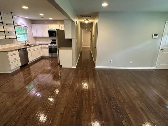 a view of a kitchen with wooden floor and a sink