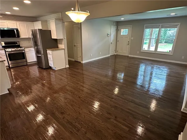 a view of a dining room with furniture a chandelier and wooden floor