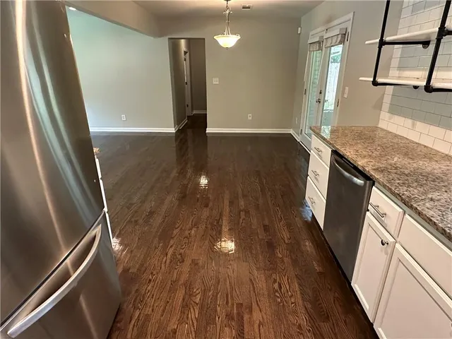 a view of a kitchen with wooden floor and staircase