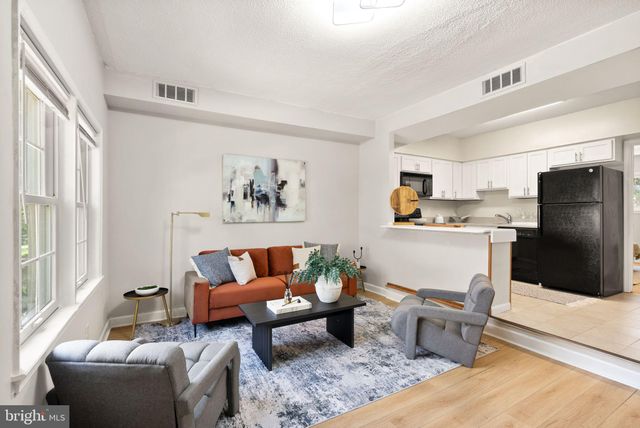 a living room with furniture and a refrigerator
