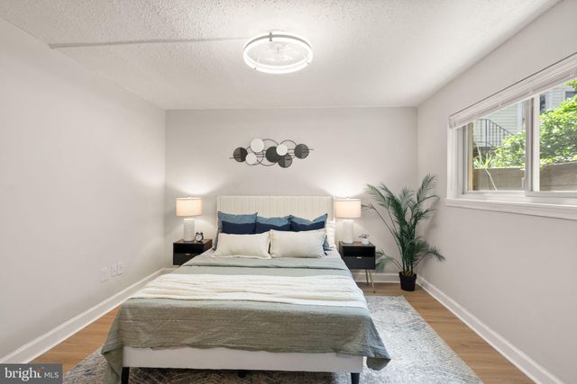 a bedroom with a large bed and a potted plant