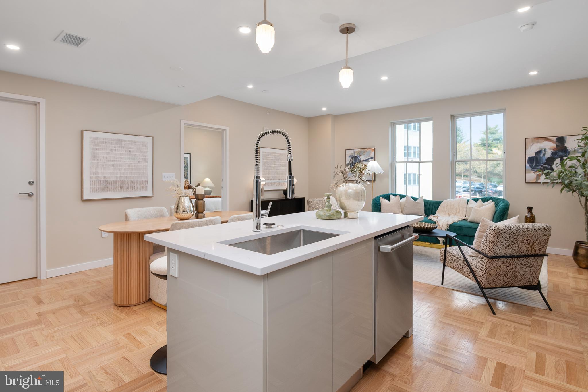 a view of living room with a sink dishwasher a dining table with wooden floor