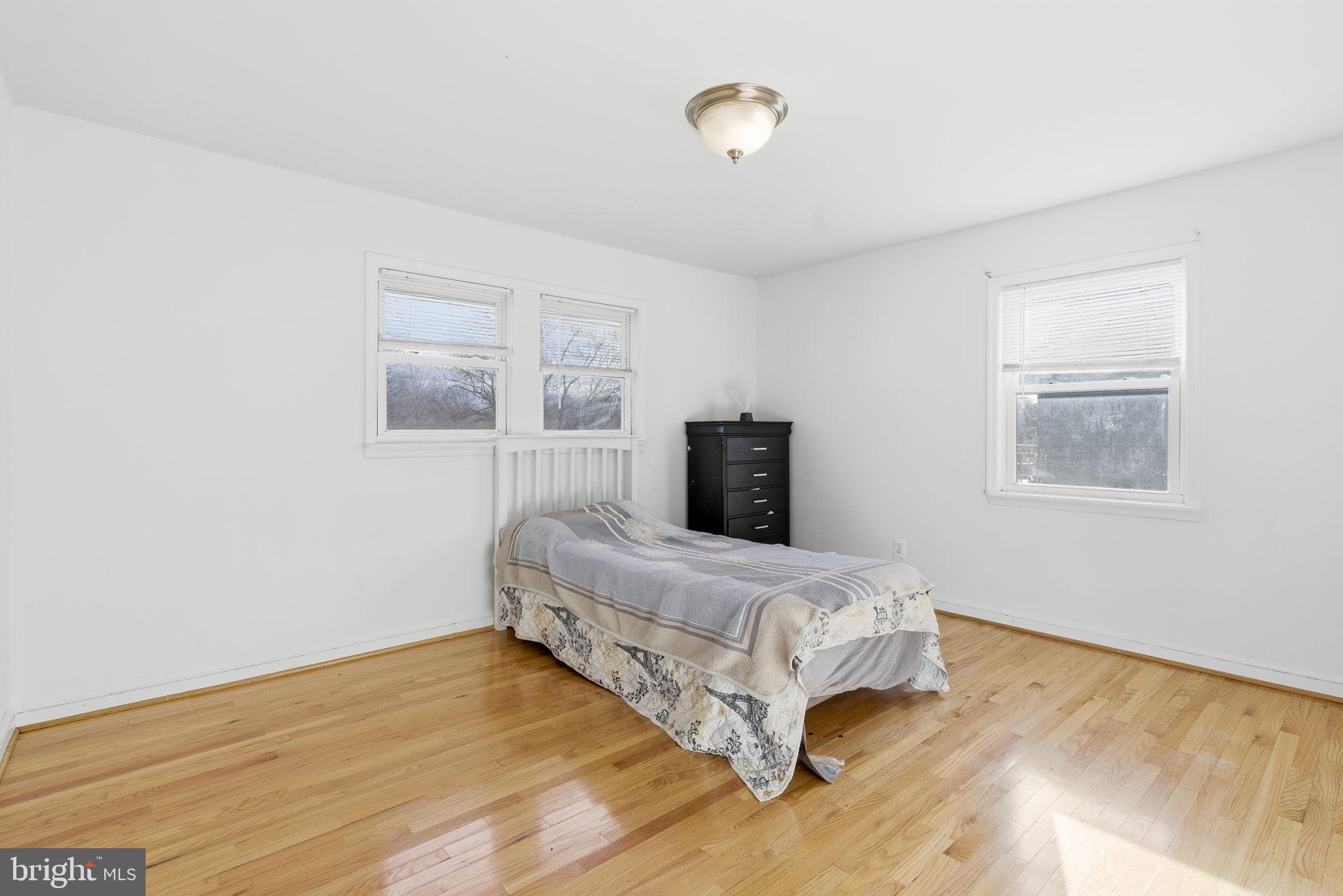 9013 Volta Street Lanham, MD 20706 - Photo 15 of 31 a bedroom with a bed and wooden floor