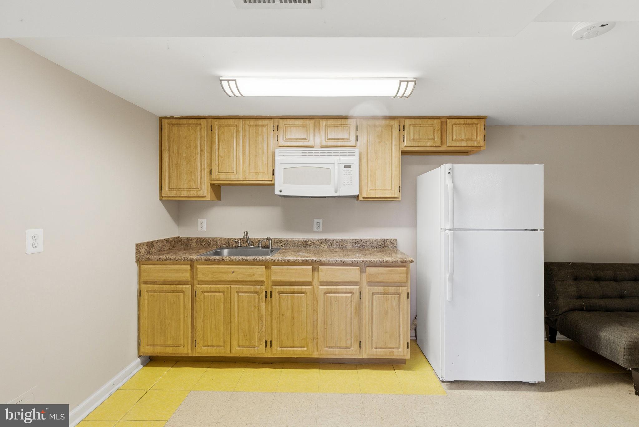 9013 Volta Street Lanham, MD 20706 - Photo 22 of 31 a kitchen with a refrigerator a stove a sink and a window