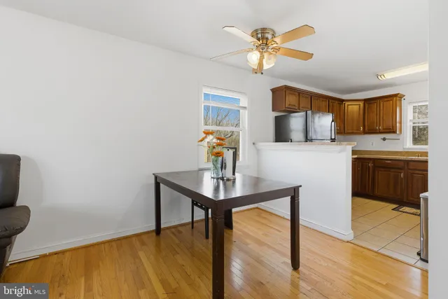 a living room with stainless steel appliances furniture a fireplace and a open kitchen view