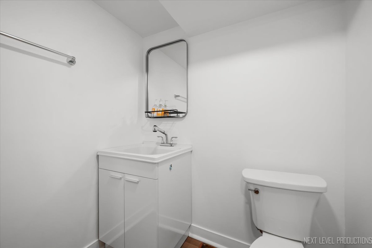 1017 South 6th Street St. Charles, IL 60174 - Photo 22 of 30 a bathroom with a toilet a sink and mirror