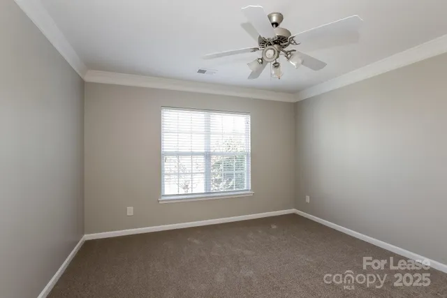 an empty room with a window and a ceiling fan